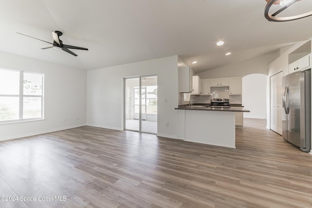 kitchen featuring appliances with stainless steel finishes, vaulted ceiling, white cabinets, and light wood-type flooring