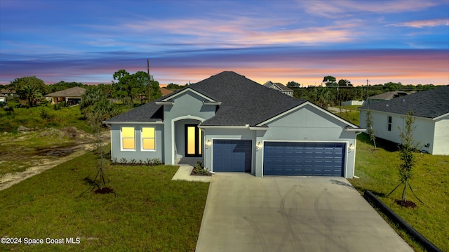 view of front facade with a garage and a lawn