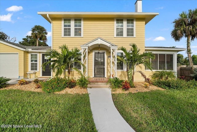 view of front of house with a front yard and a garage