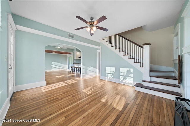 unfurnished living room featuring ceiling fan and hardwood / wood-style flooring