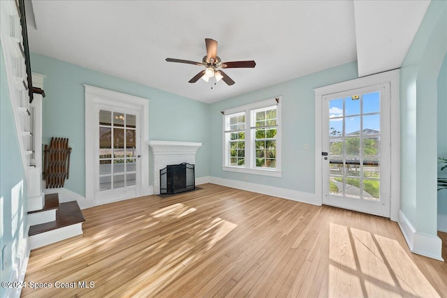 unfurnished living room featuring ceiling fan and light hardwood / wood-style floors