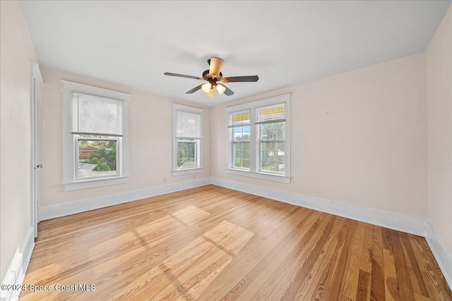 empty room with ceiling fan and light hardwood / wood-style flooring