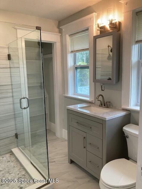 bathroom with toilet, a shower with shower door, and vanity