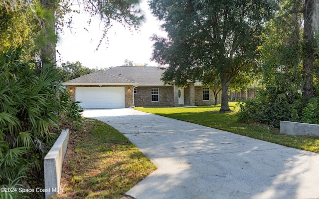 ranch-style home with a garage and a front lawn