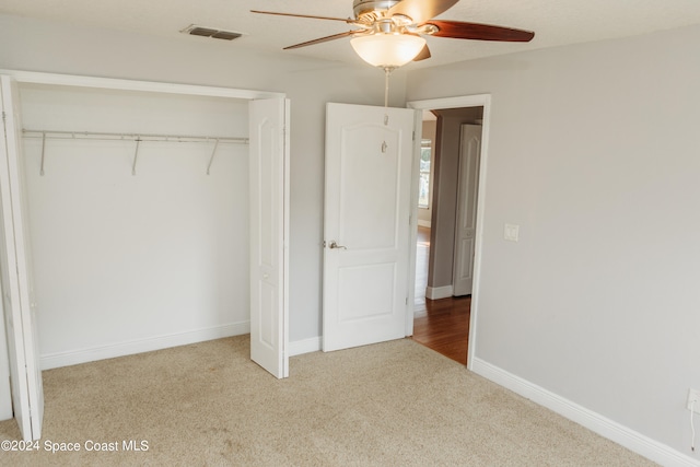 unfurnished bedroom with carpet, a closet, and ceiling fan