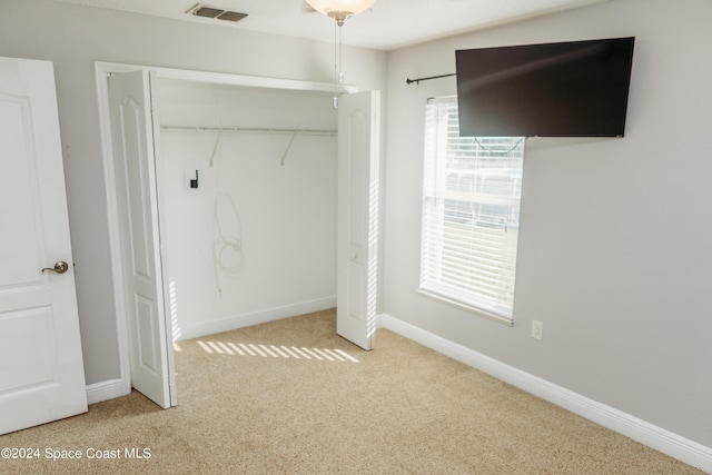 interior space featuring a closet and light colored carpet