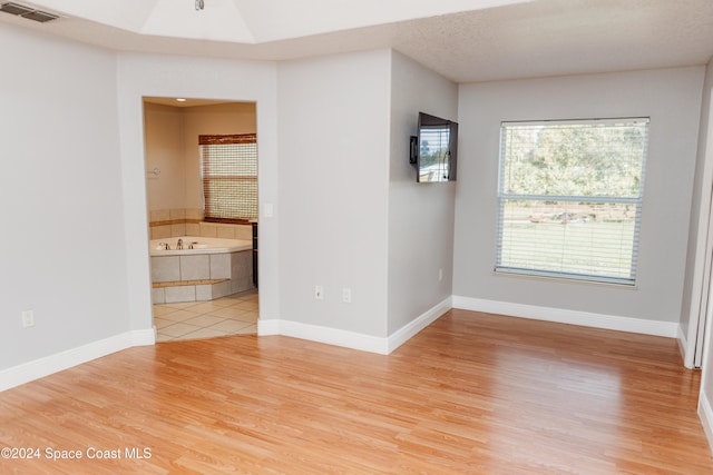 empty room featuring a textured ceiling and hardwood / wood-style flooring