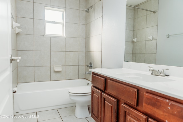 full bathroom with toilet, tiled shower / bath, vanity, and tile patterned flooring