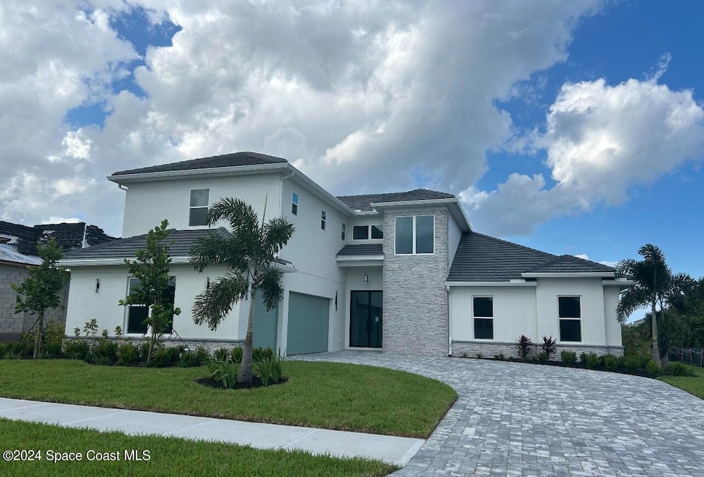 view of front of house with a front yard and a garage