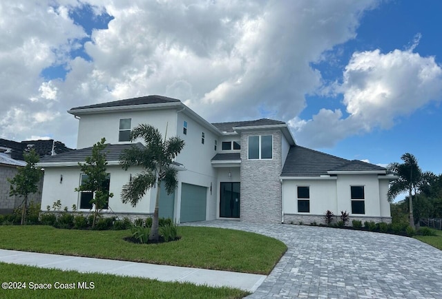 view of front of house with a front yard and a garage