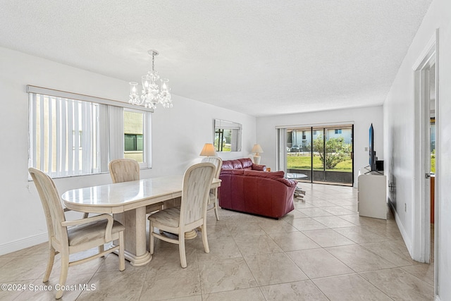 dining space featuring a chandelier, a textured ceiling, and light tile patterned floors