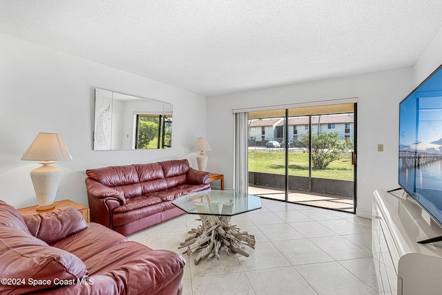 living room with a textured ceiling and light tile patterned floors