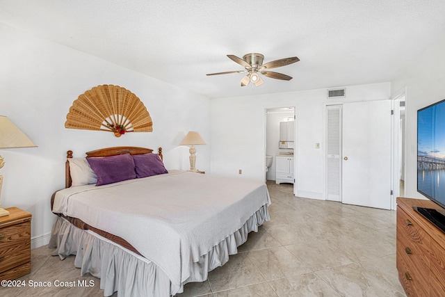 bedroom with ensuite bathroom, a textured ceiling, and ceiling fan