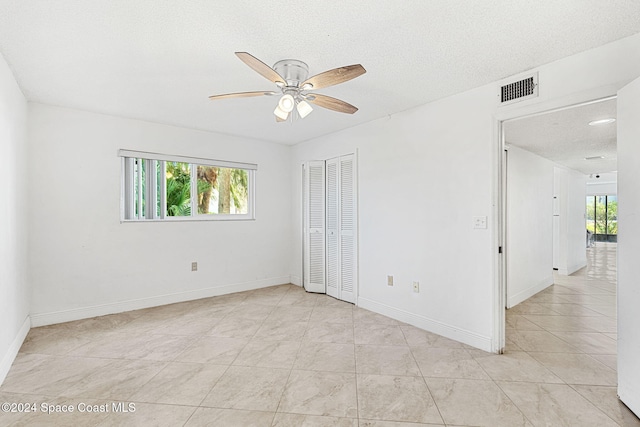 5807 N Atlantic Ave Unit 411, Cape Canaveral, FL 32920 - spare room with visible vents, light tile patterned flooring, baseboards, ceiling fan, and a textured ceiling