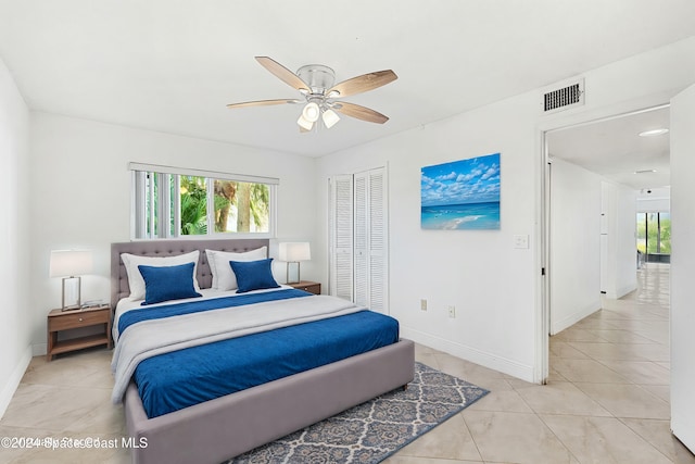 5807 N Atlantic Ave Unit 411, Cape Canaveral, FL 32920 - bedroom featuring a ceiling fan, visible vents, light tile patterned floors, baseboards, and a closet