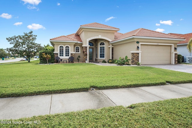 mediterranean / spanish-style house with a front lawn and a garage