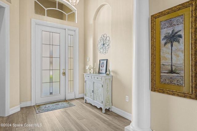 entryway featuring light hardwood / wood-style floors and decorative columns