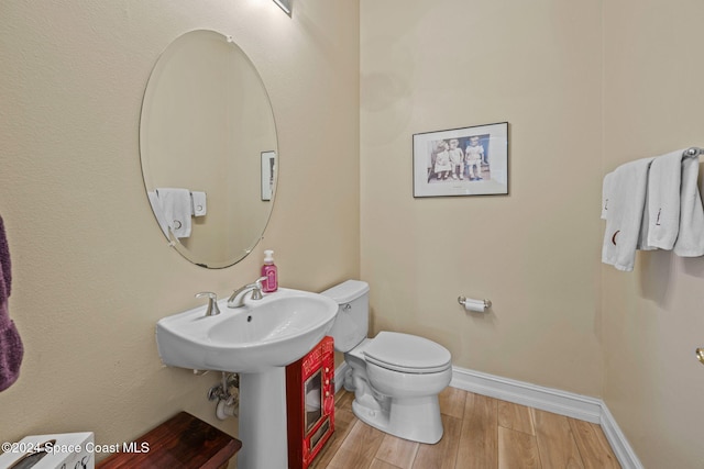 bathroom with toilet and hardwood / wood-style floors