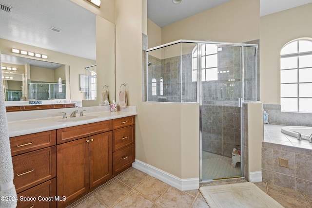 bathroom featuring vanity, independent shower and bath, a healthy amount of sunlight, and tile patterned flooring