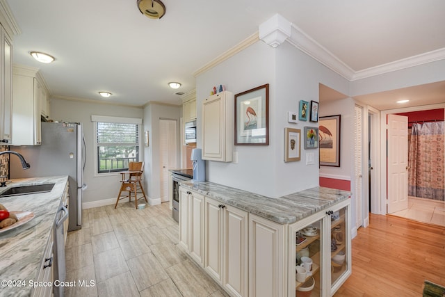 kitchen featuring crown molding, sink, light stone countertops, light hardwood / wood-style floors, and stainless steel appliances