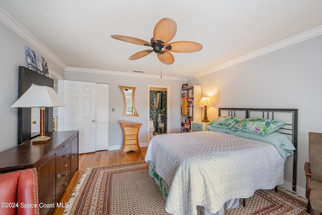 bedroom with ceiling fan, crown molding, a spacious closet, light hardwood / wood-style floors, and a closet