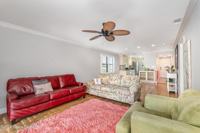 living room with hardwood / wood-style flooring, ceiling fan, and ornamental molding