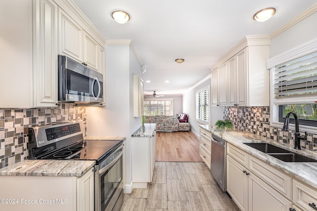 201 International Dr Unit 221, Cape Canaveral, FL 32920 - kitchen with stainless steel appliances, light stone counters, tasteful backsplash, ornamental molding, and recessed lighting