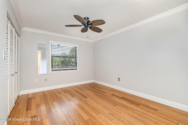 unfurnished bedroom with a closet, light hardwood / wood-style floors, ceiling fan, and crown molding