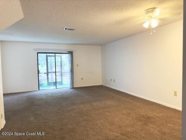 carpeted spare room featuring a textured ceiling and ceiling fan