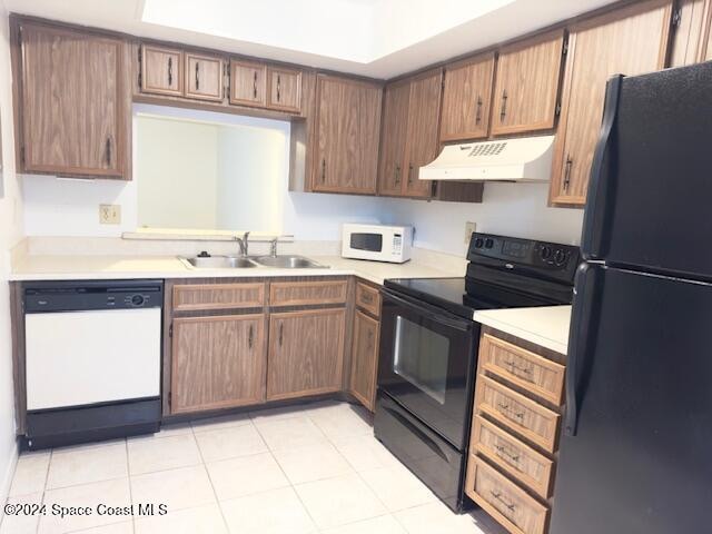 kitchen featuring light tile patterned flooring, black appliances, and sink