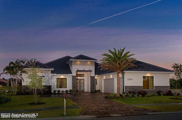 view of front of home with a garage and a yard