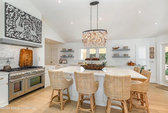 kitchen with a center island, range with two ovens, and white cabinetry