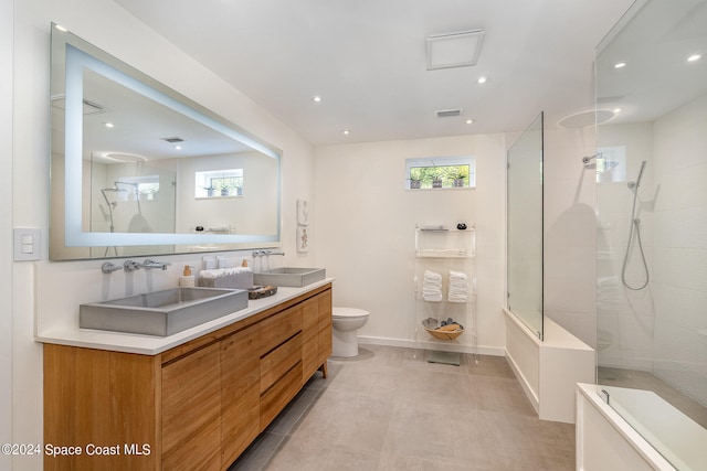 bathroom featuring toilet, vanity, a healthy amount of sunlight, and tiled shower