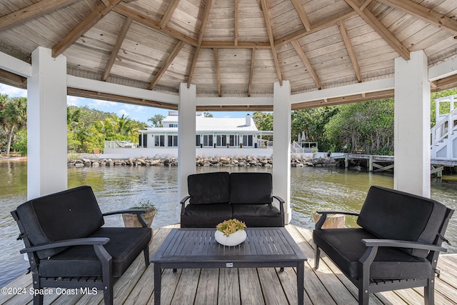 wooden deck with a gazebo, outdoor lounge area, and a water view