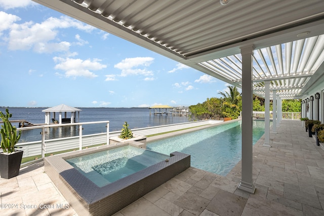 view of pool featuring a patio, a water view, and a dock