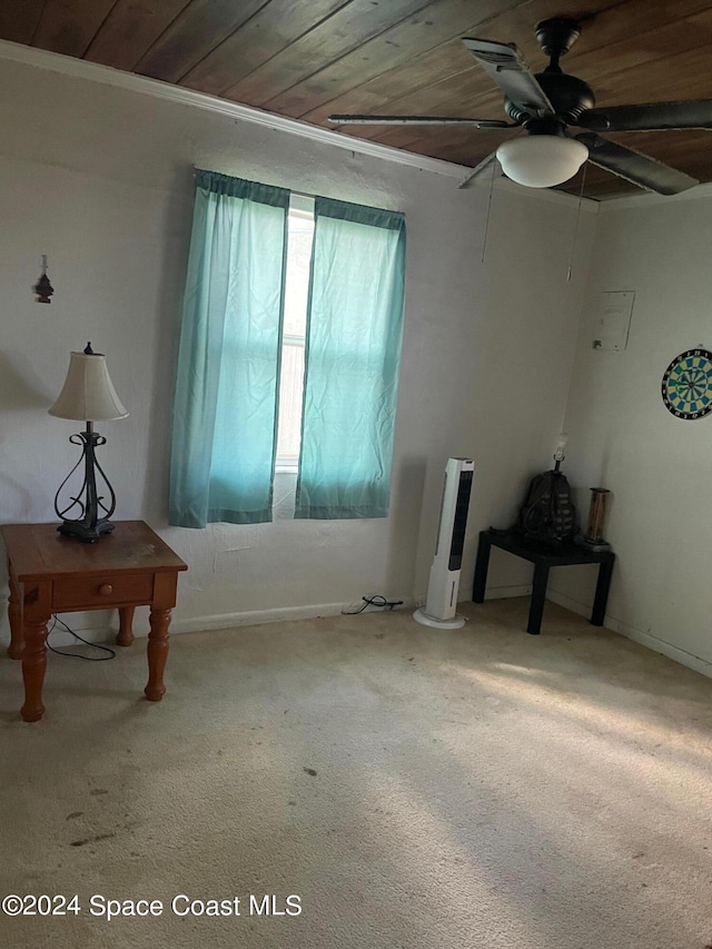 empty room featuring wood ceiling, ornamental molding, carpet, and ceiling fan