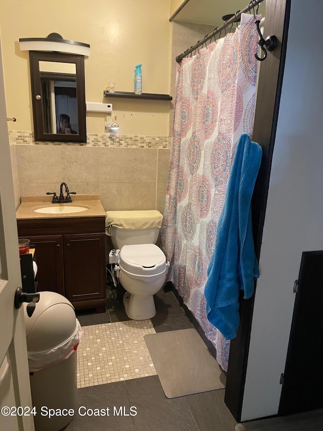 bathroom featuring vanity, toilet, tile walls, and tile patterned flooring