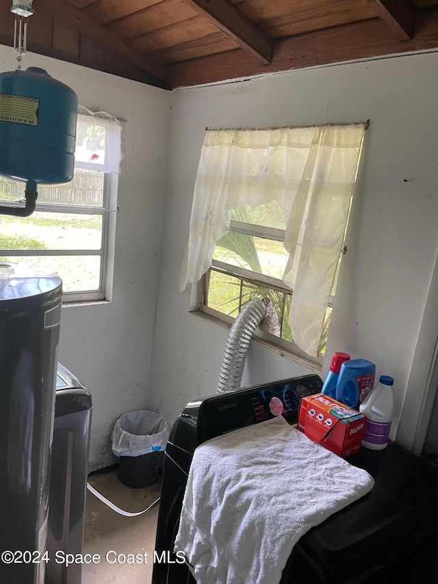 bedroom with washer / dryer, wood ceiling, and concrete floors