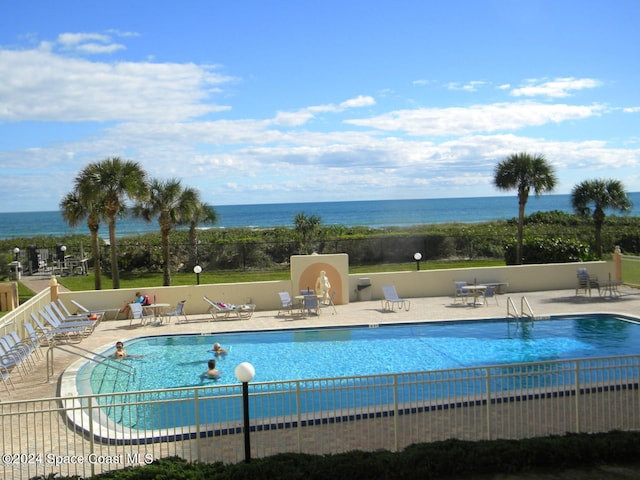 view of swimming pool with a water view and a patio area