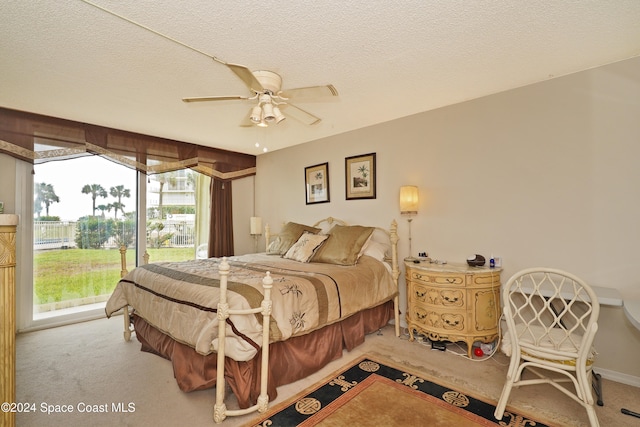 bedroom with access to outside, a textured ceiling, and carpet floors