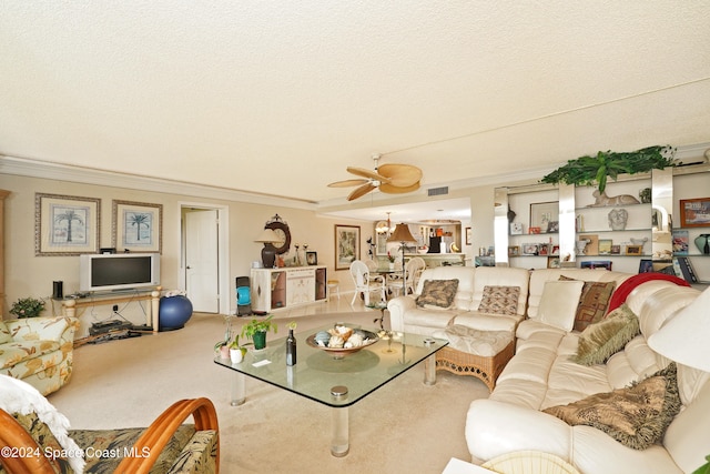 living room featuring ceiling fan, ornamental molding, and a textured ceiling