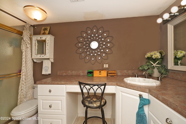 bathroom with toilet, vanity, and a shower