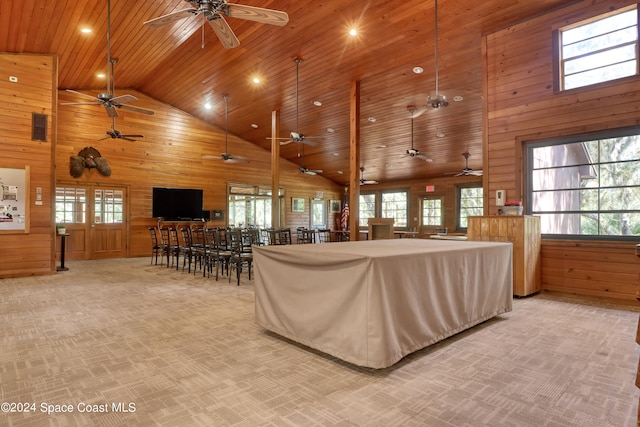 living room with a healthy amount of sunlight, wooden walls, wood ceiling, and high vaulted ceiling