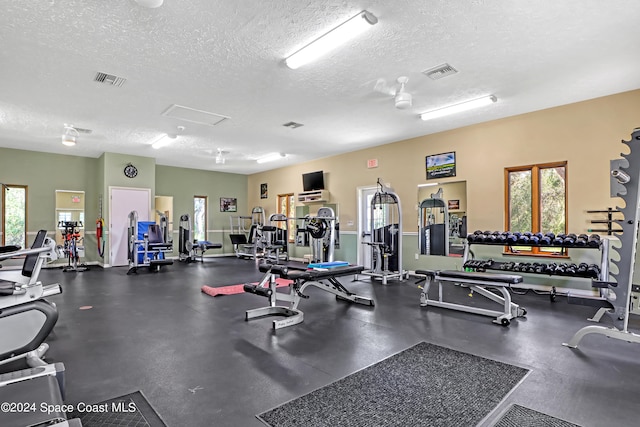 gym with a textured ceiling and plenty of natural light