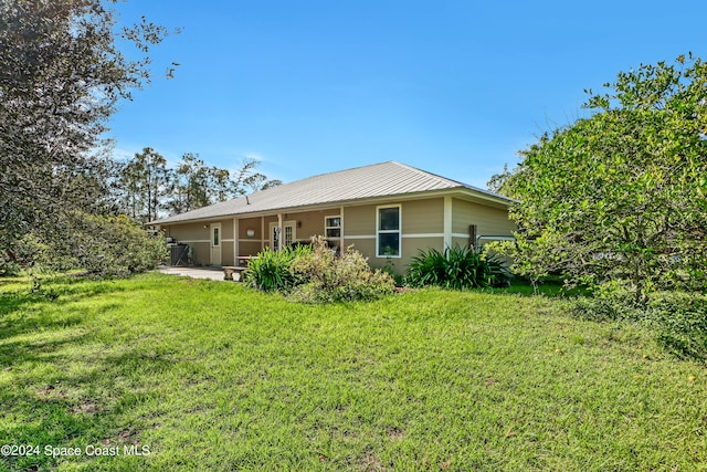 back of property with a yard and a patio area