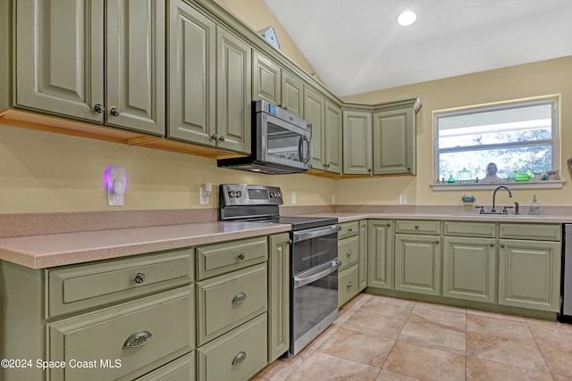 kitchen with sink, stainless steel appliances, green cabinets, and lofted ceiling