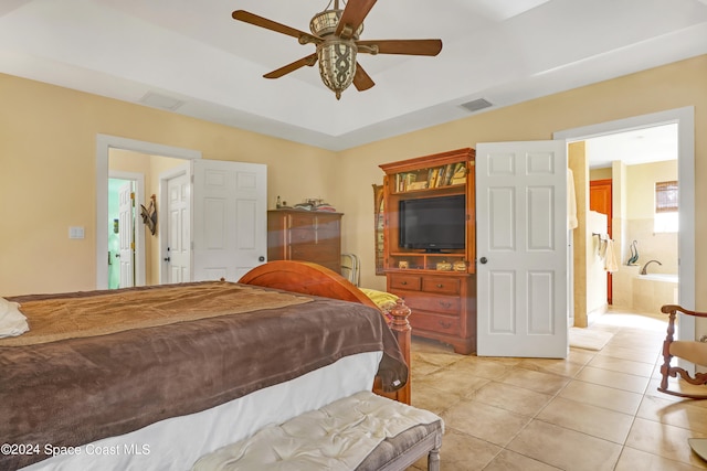 bedroom with connected bathroom, light tile patterned floors, and ceiling fan