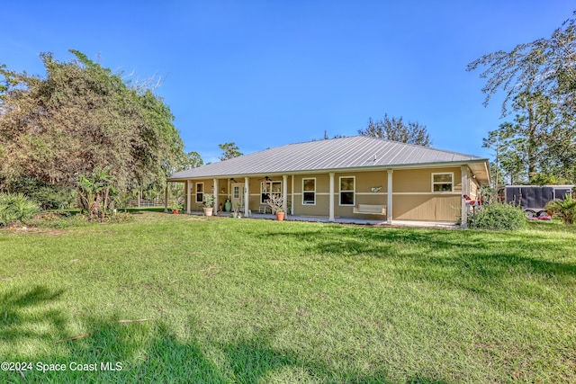 rear view of property featuring a lawn and a porch