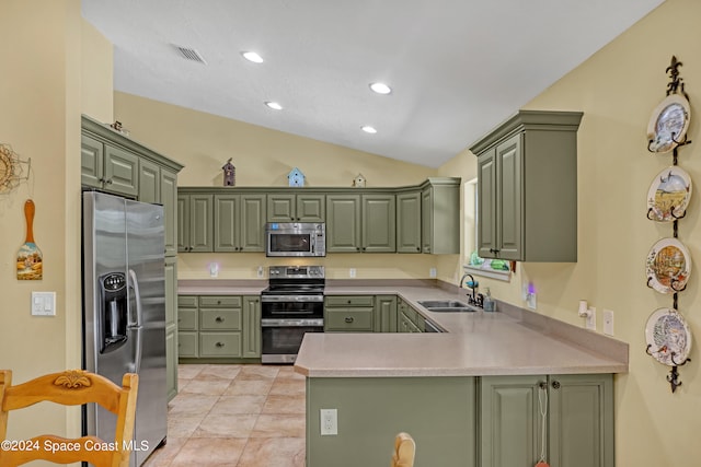 kitchen with kitchen peninsula, appliances with stainless steel finishes, lofted ceiling, and green cabinetry