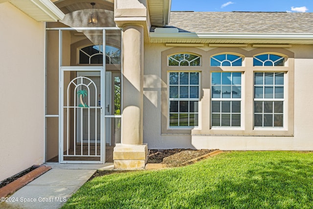 view of exterior entry with a lawn